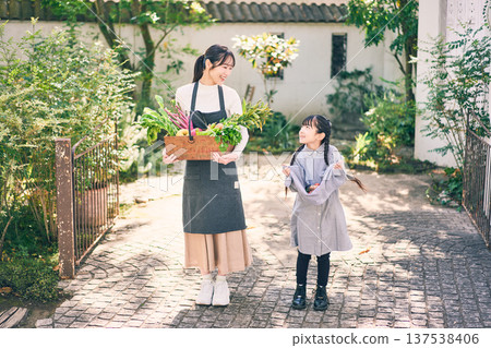 Parents and children holding vegetables in the garden 137538406