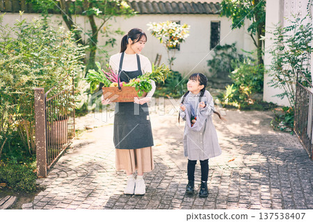 Parents and children holding vegetables in the garden Parents and children holding vegetables in the garden 137538407