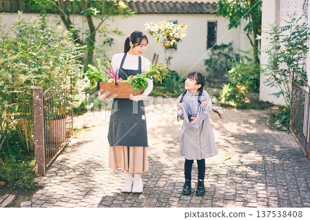 Parents and children holding vegetables in the garden Parents and children holding vegetables in the garden 137538408
