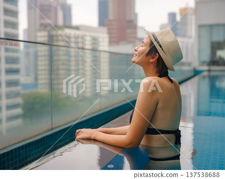 Young woman relaxing by the pool at a Kuala Lumpur hotel 137538688
