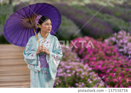 woman in yukata (kimono dress) holding umbrella with flower blooming in garden woman in yukata (kimono dress) holding umbrella with flower blooming in garden 137538756