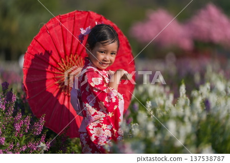 preschool child girl in yukata (kimono dress) holding umbrella with sakura flower or cherry blossom blooming in garden preschool child girl in yukata (kimono dress) holding umbrella with sakura flower or cherry blossom blooming in garden 137538787