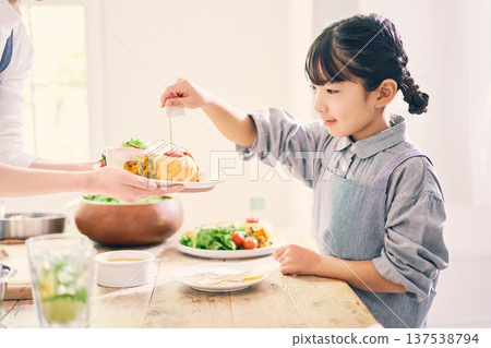 Girl helping with meal preparation Girl helping with meal preparation 137538794