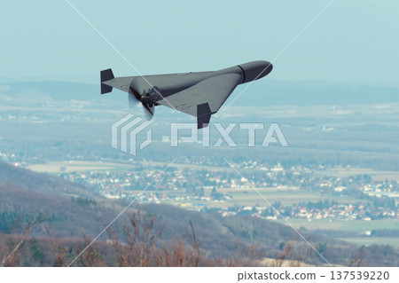 Kamikaze attack drone flies above rural landscape during war. Kamikaze attack drone flies above rural landscape during war. 137539220