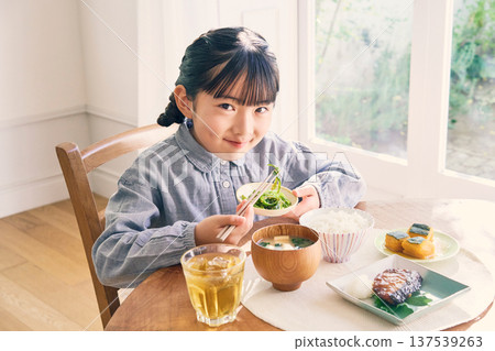 Girl eating breakfast at home Girl eating breakfast at home 137539263