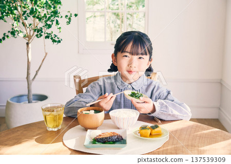 Girl eating breakfast at home Girl eating breakfast at home 137539309