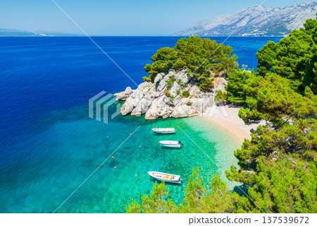 Makarska, Croatia. Crystal-clear turquoise waters and white pebble beaches in small bay of Punta Rata, Brela. Makarska, Croatia. Crystal-clear turquoise waters and white pebble beaches in small bay of Punta Rata, Brela. 137539672