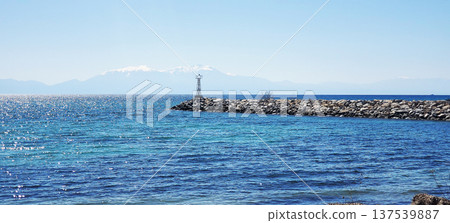 A seascape: blue water and a stone pier 137539887