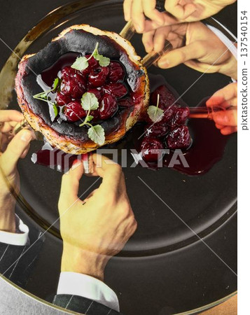 Gourmet cherry dessert featuring mint leaves and gold rim details 137540154