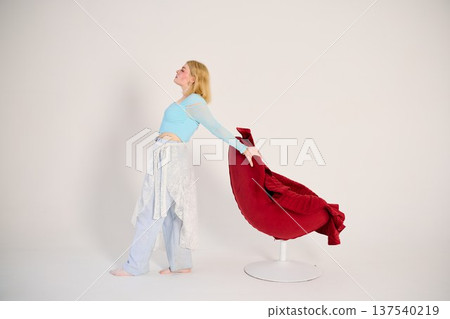 Reflective motion blonde woman walking near chair Reflective motion blonde woman walking near chair 137540219
