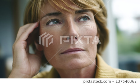 Thoughtful mature caucasian woman with short blonde hair gazing away Thoughtful mature caucasian woman with short blonde hair gazing away 137540362