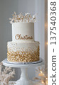 Elegant white and gold two-tier cake with floral topper. National Christina Day 137540368