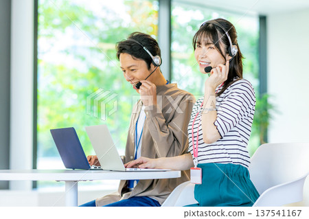 Male and female operators working in the office Male and female operators working in the office 137541167