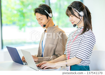 Male and female operators working in the office Male and female operators working in the office 137541170