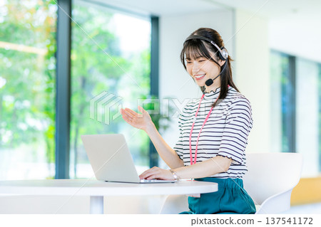 在呼叫中心工作的年輕女子 在呼叫中心工作的年輕女子 137541172