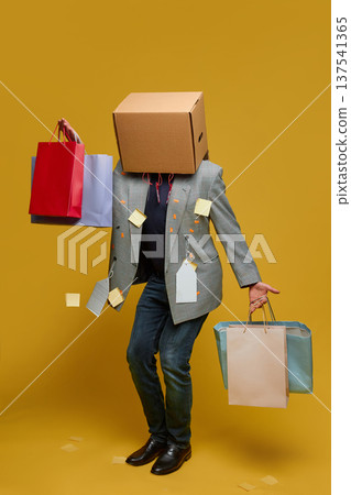 Anonymous shopper with box head holding shopping bags sale 137541365