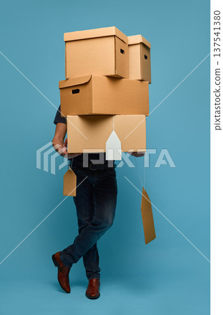 Man hidden behind stack of cardboard price tag boxes retail concept Man hidden behind stack of cardboard price tag boxes retail concept 137541380