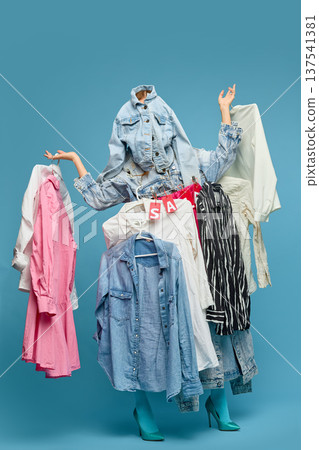 Woman surrounded by hanging clothes fashion shopping concept Woman surrounded by hanging clothes fashion shopping concept 137541381