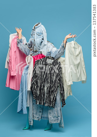 Fashion shopping overload woman hidden behind hanging clothes 137541383