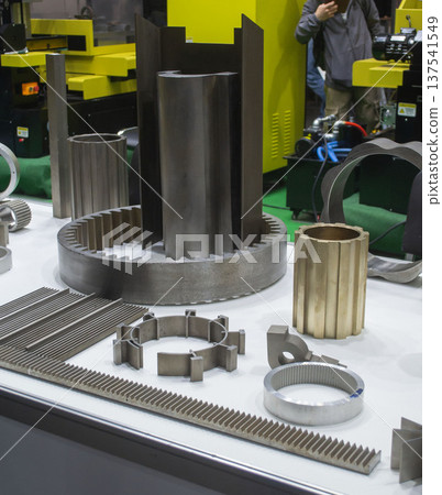Different metal models on a white surface. Many metal products close-up. Various metal parts of gear transmissions. Gear wheels. Metal processing. Industrial metalworking objects. Steel manufacturing Different metal models on a white surface. Many metal products close-up. Various metal parts of gear transmissions. Gear wheels. Metal processing. Industrial metalworking objects. Steel manufacturing 137541549