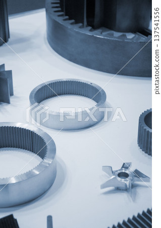 Different metal models on a white surface. Many metal products close-up. Various metal parts of gear transmissions. Gear wheels. Metal processing. Industrial metalworking objects. Steel manufacturing Different metal models on a white surface. Many metal products close-up. Various metal parts of gear transmissions. Gear wheels. Metal processing. Industrial metalworking objects. Steel manufacturing 137541556