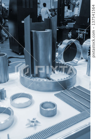 Different metal models on a white surface. Many metal products close-up. Various metal parts of gear transmissions. Gear wheels. Metal processing. Industrial metalworking objects. Steel manufacturing 137541564