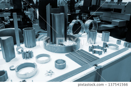 Different metal models on a white surface. Many metal products close-up. Various metal parts of gear transmissions. Gear wheels. Metal processing. Industrial metalworking objects. Steel manufacturing 137541566