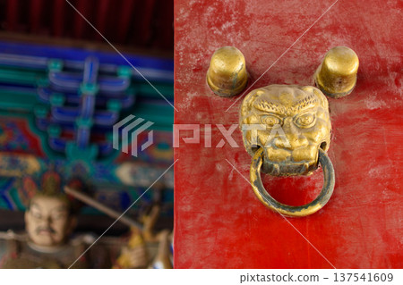 Brass lion door knocker on red temple door Brass lion door knocker on red temple door 137541609