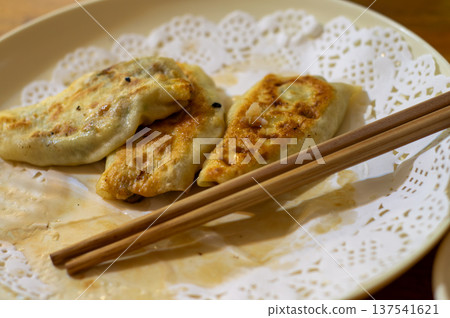 Pan-fried dumplings with chopsticks on plate Pan-fried dumplings with chopsticks on plate 137541621