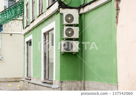 air conditioning on facade of building, air cooling in hot weather. air conditioning on facade of building, air cooling in hot weather. 137542060