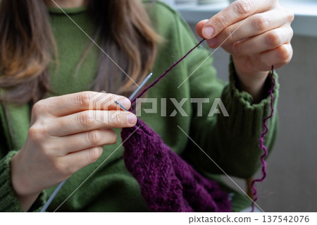 woman knits wool clothes knitting needles. skills of making clothes from yarn, hobbies meditation. woman knits wool clothes knitting needles. skills of making clothes from yarn, hobbies meditation. 137542076