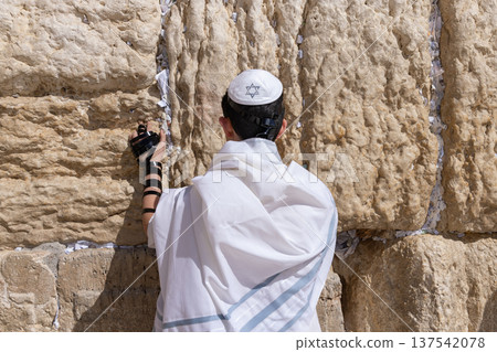 Jewish teenager praying at the Western wall in Jerusalem Jewish teenager praying at the Western wall in Jerusalem 137542078