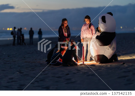 Children launching lantern on beach at dusk 137542135