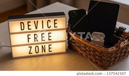 Lightbox device free zone sign with basket of phones tablets and earbuds for home office wellness corner and declutter reminder Lightbox device free zone sign with basket of phones tablets and earbuds for home office wellness corner and declutter reminder 137542307