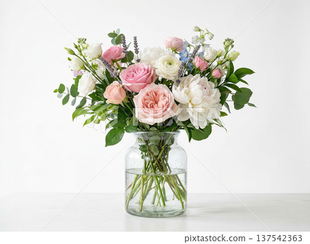 Elegant Pastel Floral Arrangement with Peonies and Roses in a Clear Glass Vase on a White Surface 137542363