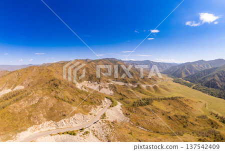 Aerial panoramic view to Chuysky Trakt near by Chike-Taman pass. Mountain serpentine Chuya Highway on sunny autumn day. Asphalt road going through cliff. Altai Region, Blue sky. Siberia, Russia. Asia. Aerial panoramic view to Chuysky Trakt near by Chike-Taman pass. Mountain serpentine Chuya Highway on sunny autumn day. Asphalt road going through cliff. Altai Region, Blue sky. Siberia, Russia. Asia. 137542409