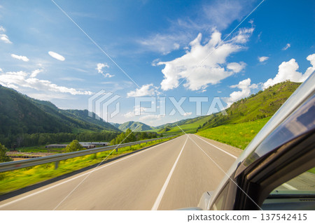 View from car of winding mountain highway. Beautiful autumn road connecting Novorossiysk and border with Mongolia. Freedom travel landscape Chuisky tract. Kurai. Altai Republic, Russia. View from car of winding mountain highway. Beautiful autumn road connecting Novorossiysk and border with Mongolia. Freedom travel landscape Chuisky tract. Kurai. Altai Republic, Russia. 137542415