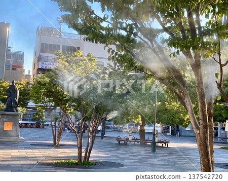 Kofu Station North Exit Square in summer, where mist is sprayed to combat the heat. 137542720