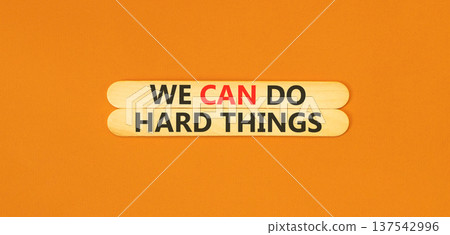 Support, help we can do hard things symbol. Concept words We can do hard things on beautiful wooden sticks. Beautiful orange background. Business we can do hard things concept. Copy space. Support, help we can do hard things symbol. Concept words We can do hard things on beautiful wooden sticks. Beautiful orange background. Business we can do hard things concept. Copy space. 137542996