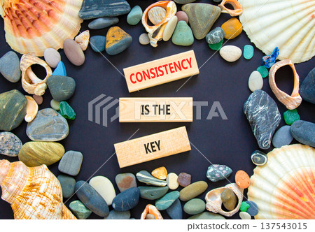 Consistency is the key symbol. Concept words Consistency is the key on beautiful wooden blocks. Beautiful black background. Sea shells and stones. Business consistency is the key concept. Copy space. 137543015