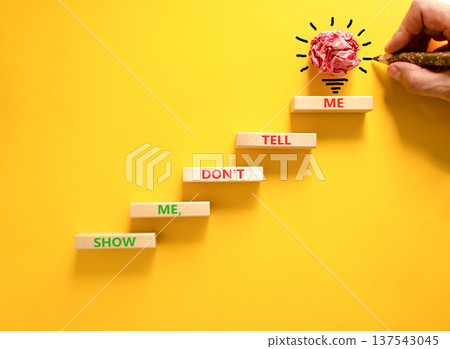 Tell or show symbol. Concept words Show me, do not tell me on beautiful wooden blocks. Beautiful yellow paper background. Light bulb icon. Businessman hand. Business tell or show concept. Copy space. Tell or show symbol. Concept words Show me, do not tell me on beautiful wooden blocks. Beautiful yellow paper background. Light bulb icon. Businessman hand. Business tell or show concept. Copy space. 137543045