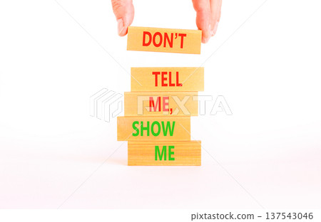 Tell or show symbol. Concept words Do not tell me, show me on beautiful wooden blocks. Beautiful white paper background. Businessman hand. Business tell or show concept. Copy space. Tell or show symbol. Concept words Do not tell me, show me on beautiful wooden blocks. Beautiful white paper background. Businessman hand. Business tell or show concept. Copy space. 137543046