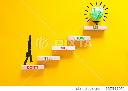 Tell or show symbol. Concept words Do not tell me, show me on beautiful wooden blocks. Beautiful yellow paper background. Light bulb icon. Businesswoman icon. Business tell or show concept. Copy space Tell or show symbol. Concept words Do not tell me, show me on beautiful wooden blocks. Beautiful yellow paper background. Light bulb icon. Businesswoman icon. Business tell or show concept. Copy space 137543051