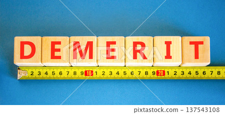 Demerit symbol. Concept word Demerit on beautiful wooden blocks. Beautiful blue background. Beautiful yellow ruler. Business demerit concept. Copy space. Demerit symbol. Concept word Demerit on beautiful wooden blocks. Beautiful blue background. Beautiful yellow ruler. Business demerit concept. Copy space. 137543108