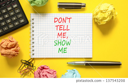 Tell or show symbol. Concept words Do not tell me, show me on beautiful white note. Beautiful yellow background. Black calculator. Black pen. Business tell or show concept. Copy space. Tell or show symbol. Concept words Do not tell me, show me on beautiful white note. Beautiful yellow background. Black calculator. Black pen. Business tell or show concept. Copy space. 137543208
