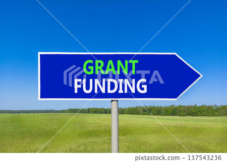Grant funding symbol. Concept words Grant funding on beautiful blue road sign. Beautiful blue sky green grass field background. Business and grant funding concept. Copy space. Grant funding symbol. Concept words Grant funding on beautiful blue road sign. Beautiful blue sky green grass field background. Business and grant funding concept. Copy space. 137543236