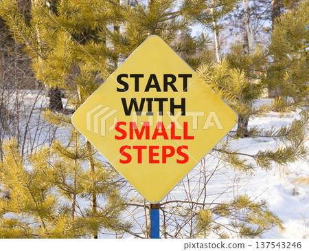 Start with small steps symbol. Concept words phrase Start with small steps on beautiful yellow road sign. Beautiful winter forest background. Business Start with small steps concept. Copy space. 137543246