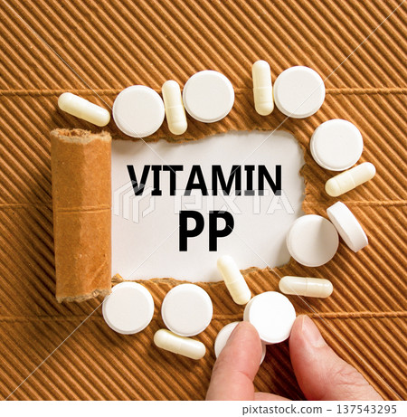 Vitamin PP symbol. Concept words Vitamin PP on beautiful white paper. White pills tablets. Doctor's hand. Beautiful brown background. Medical healthy lifestyle Vitamin PP concept. Vitamin PP symbol. Concept words Vitamin PP on beautiful white paper. White pills tablets. Doctor's hand. Beautiful brown background. Medical healthy lifestyle Vitamin PP concept. 137543295