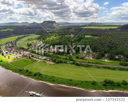 A panoramic, picturesque view of the Elbe River bend in the Saxon Switzerland National Park against a blue cloudy sky. 137543372