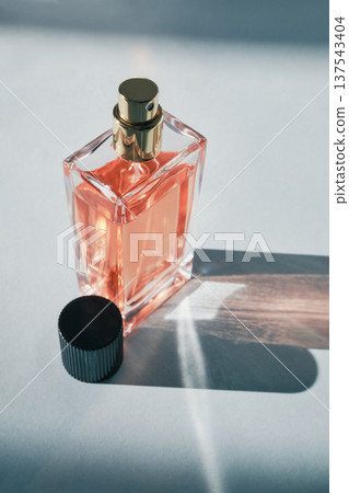 Elegant glass perfume bottle reflecting light on white background 137543404